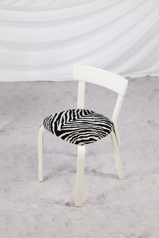 Artek 69 -tuolit, valkoinen runko ja Zebra-verhoilu
