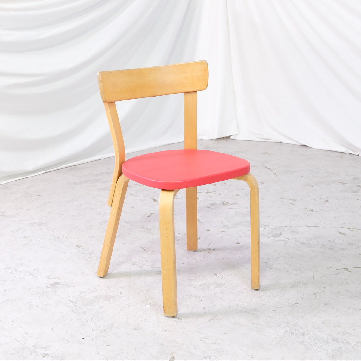 Alvar Aalto 69 -tuoli, valmistaja Artek, punainen verhoilu