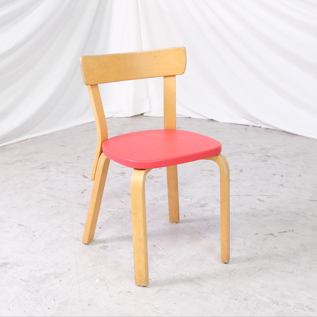 Alvar Aalto 69 -tuoli, valmistaja Artek, punainen verhoilu