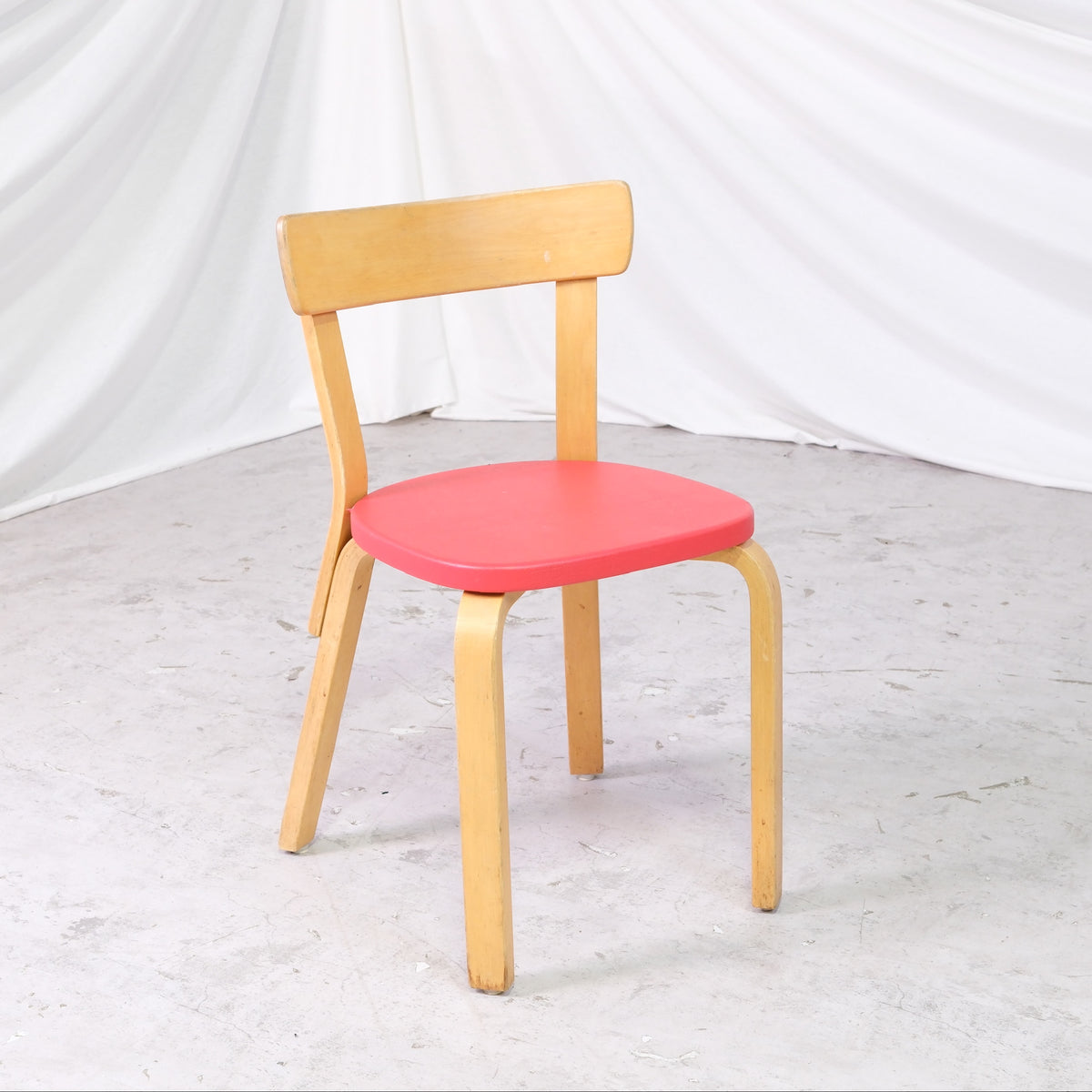 Alvar Aalto 69 -tuoli, valmistaja Artek, punainen verhoilu