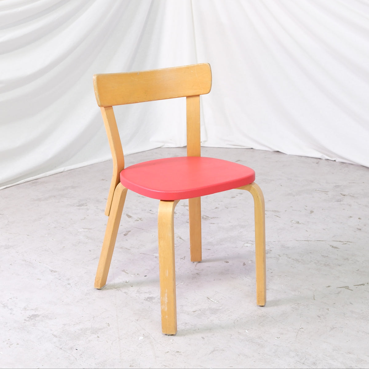 Alvar Aalto 69 -tuoli, valmistaja Artek, punainen verhoilu