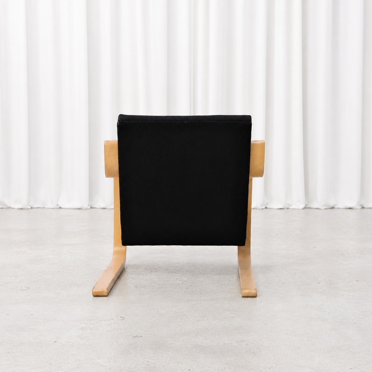 Rear view of a 1960s Artek 402 armchair with black fabric upholstery